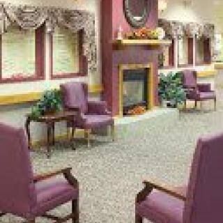A cozy living room with purple chairs and a fireplace.