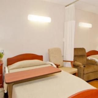 A hospital room with beds and chairs, providing a comfortable healthcare environment.