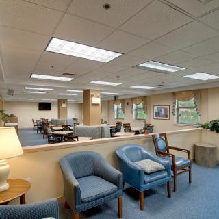 A spacious waiting room with several seating arrangements and bright lighting.