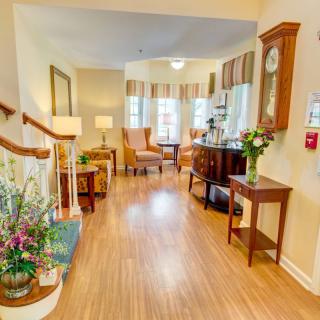 A cozy and beautifully decorated hallway with comfortable seating and floral arrangements.