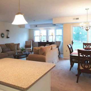 A cozy open floor plan living and dining area with comfortable seating and elegant lighting.