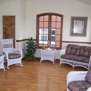 A cozy living room featuring wicker furniture and a bright window.