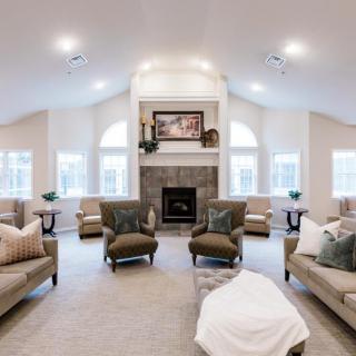 A spacious and elegantly designed living room with ample seating and a central fireplace.
