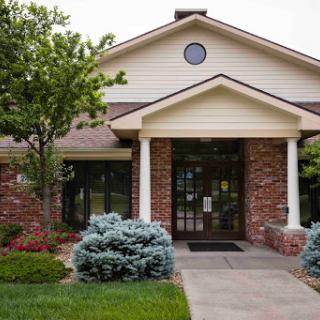 A welcoming entrance of a residential building surrounded by well-maintained landscaping.
