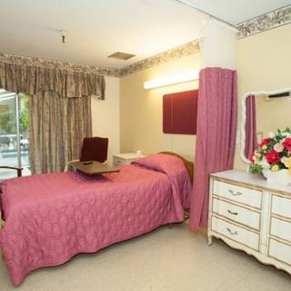 A well-decorated bedroom featuring a single bed, floral arrangement, and elegant furnishings.