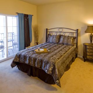 A cozy bedroom with a nicely made bed and elegant furnishings.