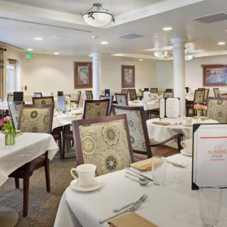 An elegantly set dining room with multiple tables and chairs ready for guests.
