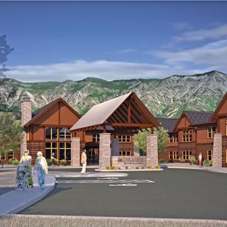 A scenic view of a resort-style building set against a backdrop of mountains.