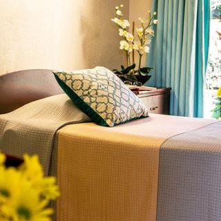 A cozy bedroom setting with a neatly made bed, decorative pillows, and soft lighting.