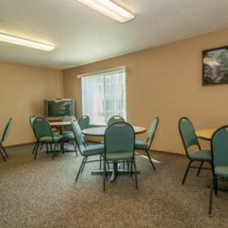 A small meeting room with several tables and chairs arranged around the space.