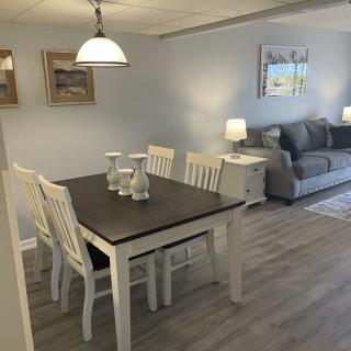 A cozy dining and living area with a wooden table, chairs, and a comfortable sofa.