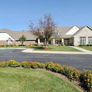A suburban house with a well-maintained front yard and driveway on a sunny day.