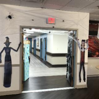 A creatively decorated entrance to a hallway, featuring spooky figures on either side.