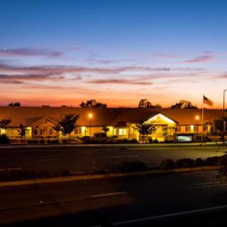 A serene view of a building at sunset, with a colorful sky in the background.