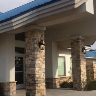 Entrance of a building with stone columns and a blue roof.