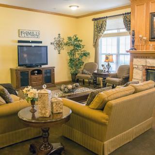 A cozy living room with comfortable seating, a television, and a fireplace.