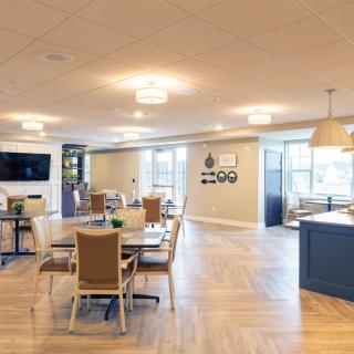 A modern and spacious dining area with tables and chairs, featuring a sleek design and ample lighting.