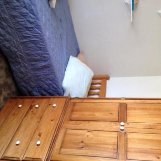 A cozy bedroom with a wooden bed and wardrobe.