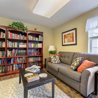 A cozy living room with a plush sofa, a well-stocked bookshelf, and stylish decor.