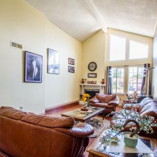 A spacious living room with comfortable sofas, a coffee table, and large windows letting in natural light.