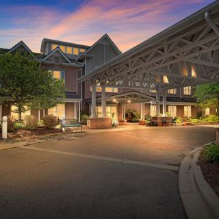 A cozy hotel entrance illuminated during the evening, showcasing its charming architecture and inviting ambiance.