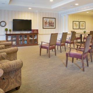 A well-arranged living room with multiple chairs facing a television.