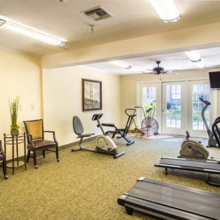 A small gym with various fitness equipment, including treadmills and stationary bikes.