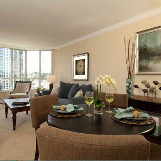 A modern apartment living room and dining area with elegant decor and a city view.