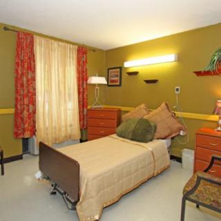 A cozy bedroom with a single bed, warm lighting, and colorful decor.