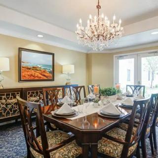 An elegantly decorated dining room with a chandelier and a neatly set table.
