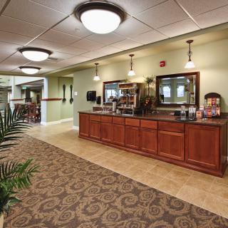 A well-lit hotel lobby with a coffee station and elegant interior design.