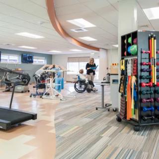 A well-equipped physical therapy and rehabilitation room with various exercise machines and equipment.