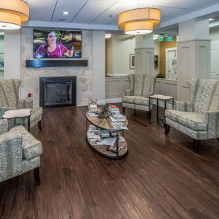A modern waiting room with comfortable seating, a television, and stylish decor.