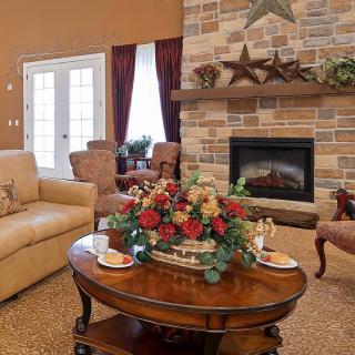 A cozy living room featuring a stone fireplace, comfortable seating, and a well-decorated coffee table.