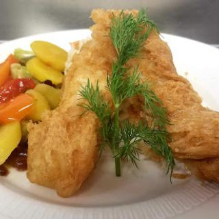 A delicious serving of fried fish accompanied by colorful vegetables.