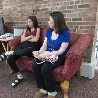 Two individuals sitting on a couch in a casual setting.