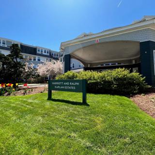 Hotel entrance with a welcoming sign and well-maintained landscaping.