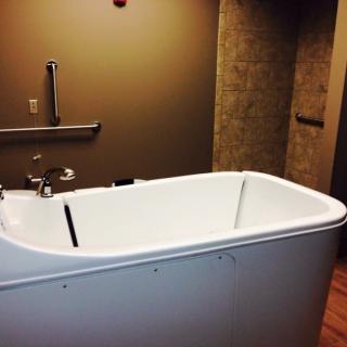 A modern, accessible bathtub in a healthcare facility bathroom.