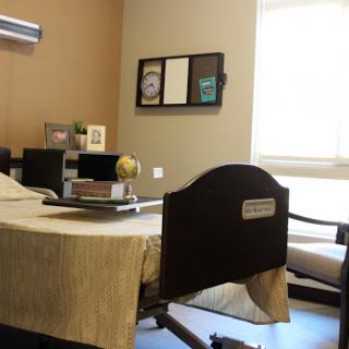 A cozy room featuring a bed, desk, and seating area illuminated by natural light.