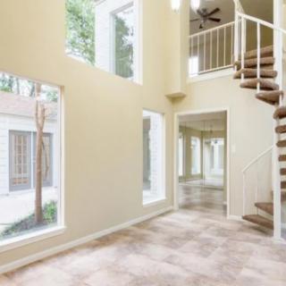 Spacious interior with large windows and a spiral staircase.