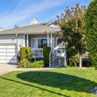 A suburban house with a neatly maintained front yard on a sunny day.