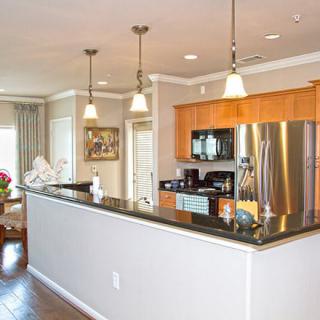 A modern kitchen with stainless steel appliances and pendant lighting in an open layout.