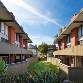 A serene residential area featuring modern apartment buildings surrounded by lush greenery.