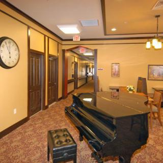 A cozy hallway interior featuring a grand piano and seating area.
