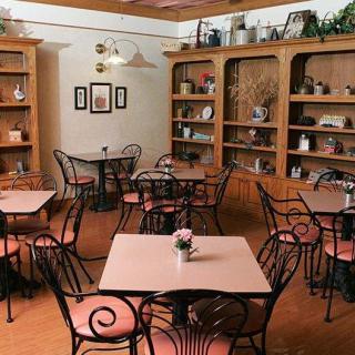 A cozy cafe interior with tables and chairs surrounded by decorative shelves.