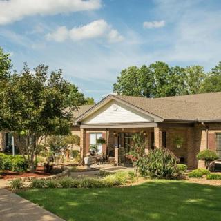 A charming suburban house with a well-maintained lawn and garden.