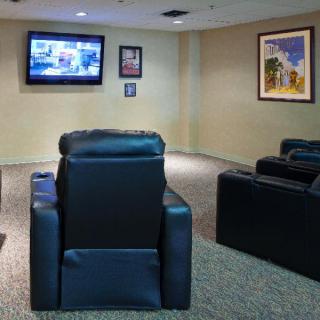 A cozy home theater setup with leather recliners facing a wall-mounted television.