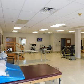 A spacious physical therapy clinic featuring various exercise equipment and treatment areas.