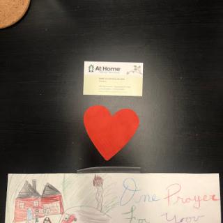 A handmade red heart surrounded by a colorful drawing and a card, symbolizing love and creativity.