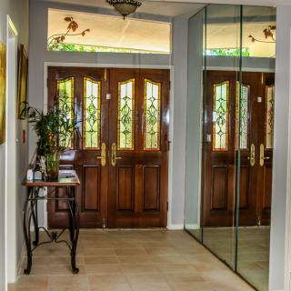 Elegant entryway with wooden double doors and mirror accents.